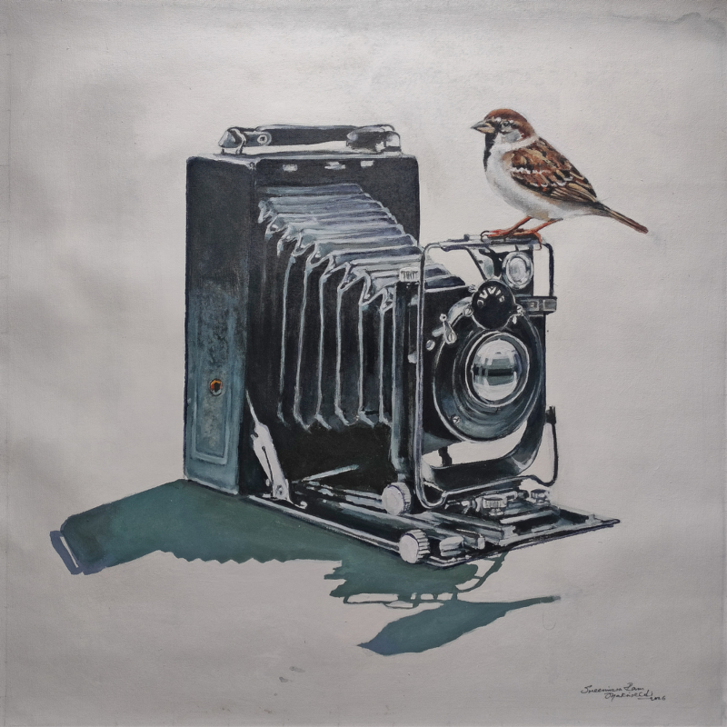A realistic acrylic painting by Mr. Shrinivasa titled Focus, featuring a detailed vintage bellows camera with a small sparrow perched on top, set against a neutral 18x18 inch canvas. 3. Product Title