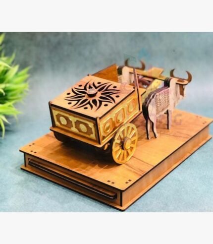 Intricately carved wooden bullock cart miniature sculpture featuring gold accents and traditional Indian craftsmanship on a decorative pedestal.