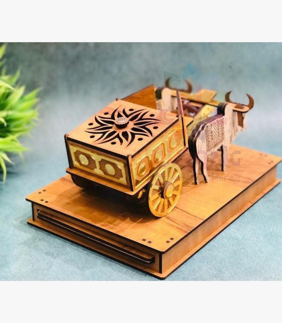Traditional Wooden Bullock Cart Handicraft Intricately carved wooden bullock cart miniature sculpture featuring gold accents and traditional Indian craftsmanship on a decorative pedestal.