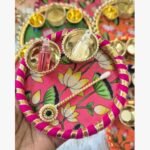Handcrafted pink lotus floral pooja thali featuring silk fabric, gota patti borders, and brass katories for ritual ceremonies.