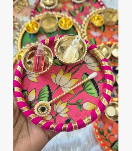 Handcrafted pink lotus floral pooja thali featuring silk fabric, gota patti borders, and brass katories for ritual ceremonies.