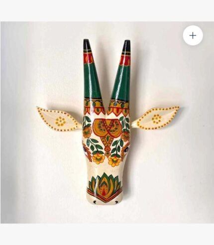 A handcrafted wooden bull head wall sculpture featuring vibrant traditional Indian folk art motifs and floral patterns on a cream background.