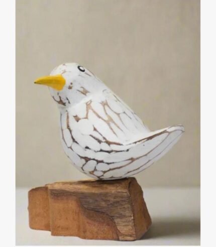A hand-carved white wooden songbird sculpture with a distressed finish perched on a natural rustic wood block base.
