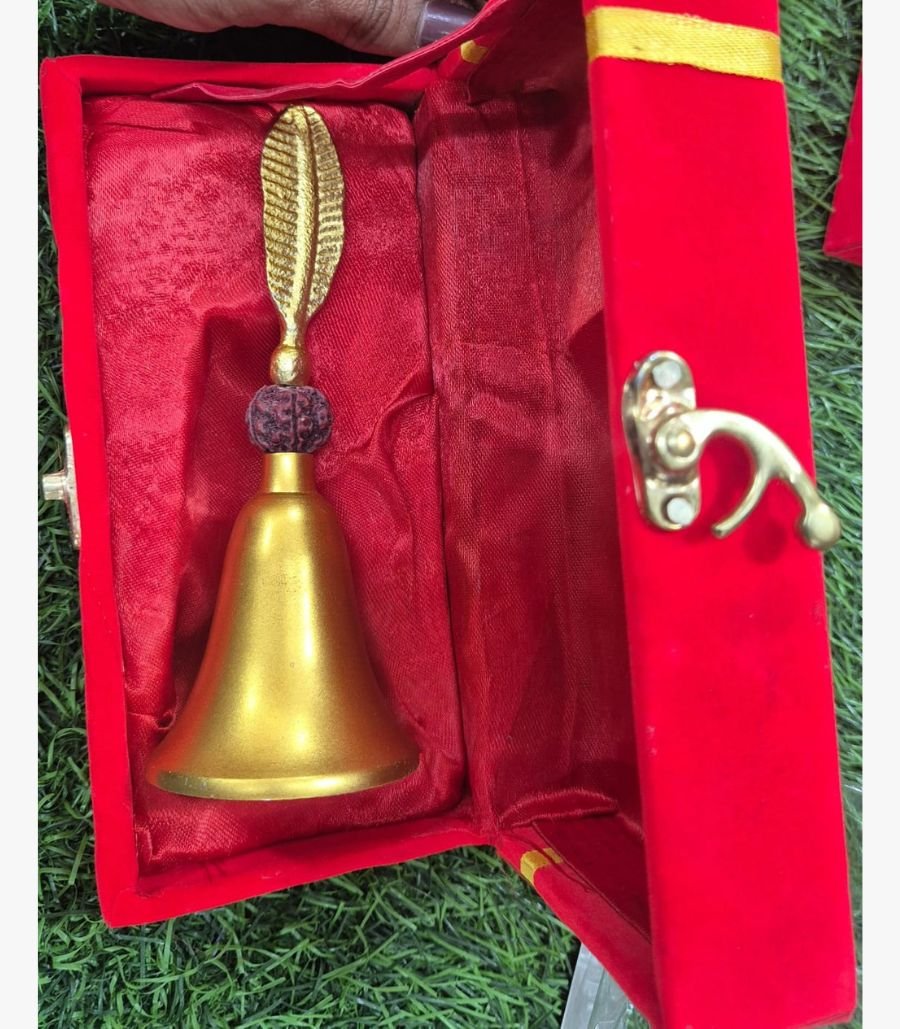 Divine Feather & Rudraksha Brass Ritual Bell A premium handcrafted gold-finish brass ritual bell featuring a sacred Rudraksha bead and an intricate leaf-motif handle, presented in a luxury red velvet box.