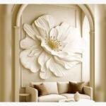A 42x48-inch hand-sculpted white plaster flower wall art piece with gold leaf stamens, titled Gilded Petal Symphony installed in an arched alcove above a neutral sofa.