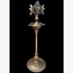 A high-end handcrafted brass ritual pooja bell featuring an intricate feather-shaped handle and a genuine Rudraksha bead in a red velvet gift box.