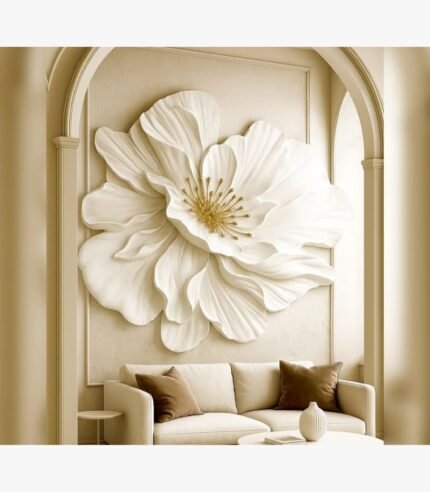 A 42x48-inch hand-sculpted white plaster flower wall art piece with gold leaf stamens, titled Gilded Petal Symphony installed in an arched alcove above a neutral sofa.