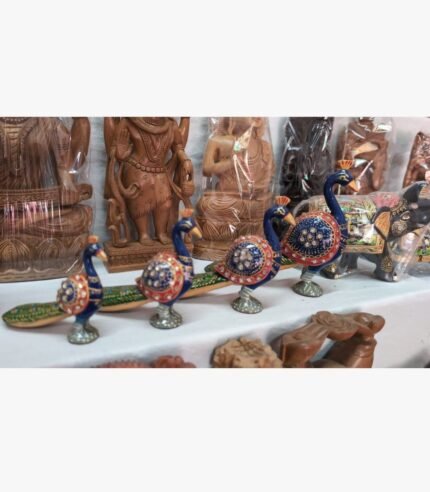 A set of hand-painted wooden peacock figurines with intricate blue paint and semi-precious stone inlay, titled Royal Peacock Procession.