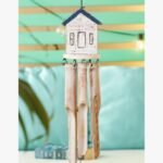 A handcrafted wind chime featuring a small white and blue wooden house top with dangling natural bamboo tubes, perfect for patio decor.