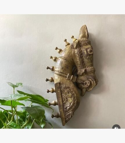 A hand-carved antique wooden horse head wall sculpture with a distressed gilded gold finish and traditional ceremonial harness details.