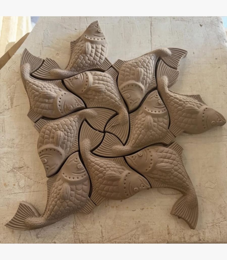 Aquatic Harmony An original sculpted relief wall piece titled 'Aquatic Harmony' featuring a geometric tessellation of interlocking fish figures in a clay-toned finish.