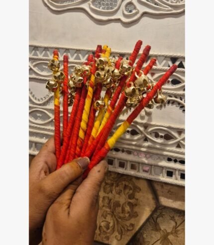 Handcrafted ritual gungroo wands wrapped in red and yellow silk thread with polished brass bells for traditional ceremonies.