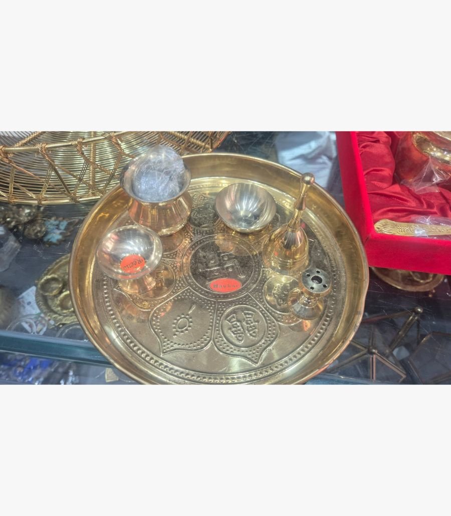 Sacred Swastika Etched Brass Pooja Set A traditional 6-piece brass pooja thali set featuring an etched Swastika central motif, ritual bell, incense holder, and prayer bowls.