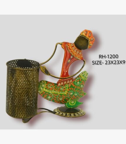 Handcrafted wrought iron traditional Indian tribal woman pen stand titled Tribal Grace by Crafts Heritage featuring vibrant red and green attire with detailed hand-painted patterns and a metallic mesh pen holder.