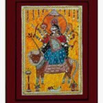 A traditional Madhubani style acrylic painting on canvas of Goddess Durga holding weapons and riding her lion vehicle against a yellow background with Devanagari script mantras by Vidhi Joshi.