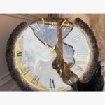 Luxury circular geode epoxy resin wall clock titled Gilded Geode Splendor by Vina Bhavsar featuring a fractured gemstone design with white, brown, and gold veins, silver Roman numerals, and textured crushed crystal borders.