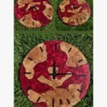 Handcrafted circular crimson red epoxy resin river wall clock titled Crimson Magma by Vina Bhavsar featuring raw live edge wood slabs embedded in metallic swirling red resin.