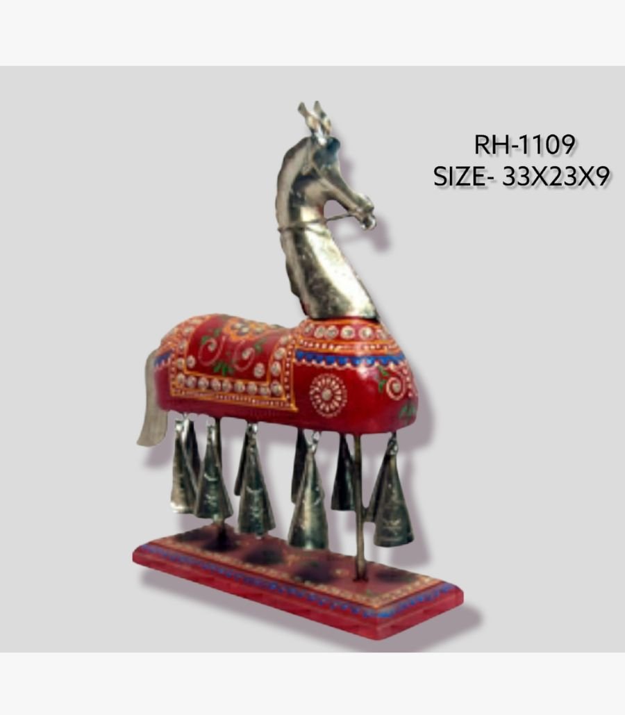 12 Handcrafted royal Rajasthani horse metal sculpture table decor featuring a red painted body with ornate gold patterns and hanging brass bells on a stable wooden base.
