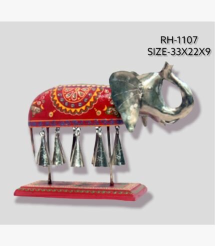 Handcrafted royal Rajasthani Ambabari elephant metal sculpture for table decor featuring an ornate red painted saddle and hanging brass bells on a sturdy pedestal.