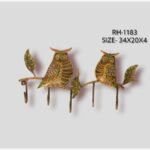 Handcrafted wrought iron decorative wall hanger with 5 hooks titled Nocturnal Guardians by Crafts Heritage featuring two vibrant hand-painted owls with folk lacquer motifs perched on a textured leafy branch.
