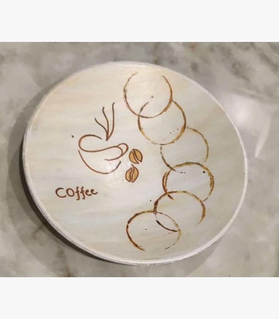 2 Handcrafted circular decorative plate titled Caffeine Rings by Vina Bhavsar featuring a minimalist cream background with a stylized coffee cup sketch, coffee beans, and overlapping brown coffee cup stain rings.