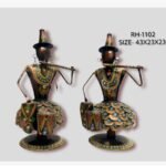 Handcrafted tribal musicians duo metal sculpture set featuring two stylized iron figures in copper tones and colorful textured skirts playing the flute and drum.