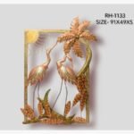 Handcrafted tropical cranes and palm tree metal wall art panel featuring two hand-painted iron crane birds standing near a patterned palm tree and sun motif inside a rectangular golden frame.