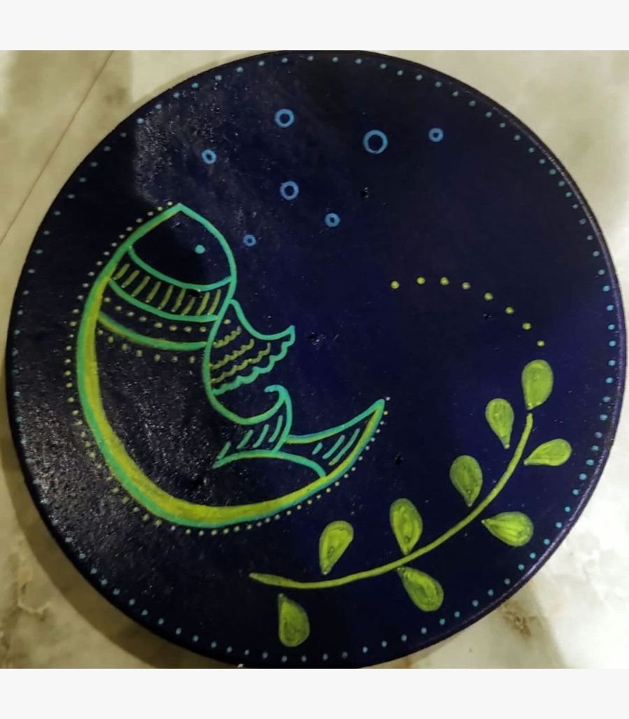 3 Handcrafted circular decorative plate titled Midnight Matsya by Vina Bhavsar featuring a minimalist stylized fish illustration in lime green and yellow outlines on a deep indigo blue background with bubbles and a botanical leaf vine.