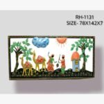 Handcrafted Rajasthani village life metal wall art panel depicting a colorful scene with dancing folk figures, a camel caravan, lush trees, and a small hut inside an embossed black frame.