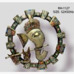 Handcrafted ornate Lord Ganesha metal wall art sculpture featuring a textured white metal face holding a flute inside an heavily painted circular floral ring frame.