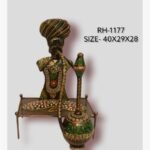 Handcrafted Rajasthani village elder hookah smoker iron sculpture featuring a multi-colored turban, patterned traditional attire, and a large green and gold hubble-bubble pipe on a metal charpai bed.