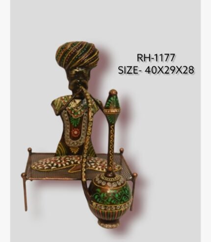 Handcrafted Rajasthani village elder hookah smoker iron sculpture featuring a multi-colored turban, patterned traditional attire, and a large green and gold hubble-bubble pipe on a metal charpai bed.
