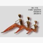 Handcrafted three-piece Rajasthani relaxing tribal figures iron sculpture set featuring hand-painted red patterned outstretched legs and metallic bronze bodices.