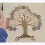 Handcrafted square multi-media wall art panel titled Golden Shrinidhi by Vina Bhavsar featuring a stylized gold tree silhouette adorned with genuine Indian coins, sparkling clear crystals, and delicate pearl beads under a protective gloss seal.