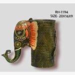 Handcrafted wrought iron royal elephant pen stand titled Regal Elephant by Crafts Heritage featuring a black painted head with vibrant orange ears and festive green and red patterns alongside a metallic perforated storage cylinder.