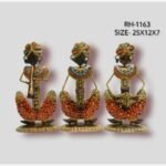 Handcrafted three-piece Rajasthani musicians iron sculpture set featuring hand-painted orange patterned dhotis, multi-colored turbans, and traditional folk instruments on flat oval bases.