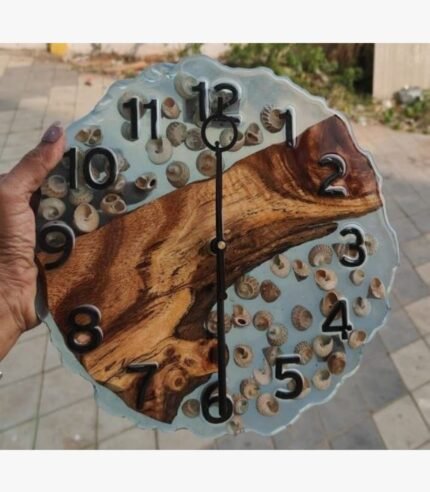 A premium scalloped-edge circular wall clock titled Ocean Echo by Vina Bhavsar combining a diagonal live edge wood slab, semi-translucent clear epoxy resin, real sea snail shells, and bold black numbers.
