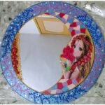 Handcrafted circular decorative mirror art titled Lunar Grace by Sabana Munshi featuring an anime-style maiden illustration within a colorful crescent moon and traditional blue Lippan clay work border.
