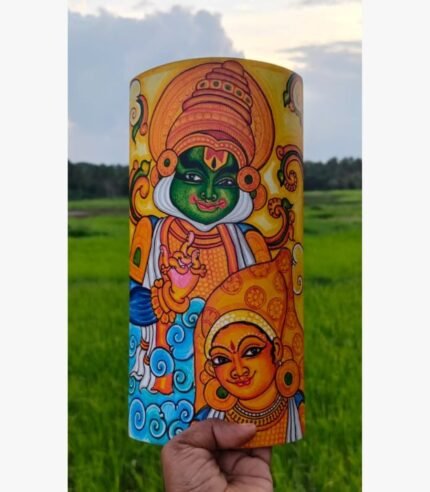 Hand-painted terracotta vase titled Divine Resonance by Akshaya Sivadas featuring a traditional Kerala mural portrait of a green-complexioned Lord Krishna playing a flute alongside Radha on a yellow ochre background.
