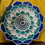 Handcrafted circular blooming lotus mandala Lippan wall art in blue, teal, and white with intricate mirror work by artist Rucha Desai.