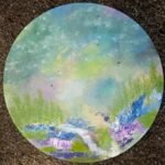An original round impressionistic acrylic canvas painting of a flowing mountain stream through a vibrant wildflower meadow by artist Jyoti Machigad.