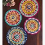 Handcrafted circular Lippan art wall plates set featuring vibrant mandala patterns and detailed mirror work by artist Rucha Desai.