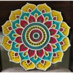 Handcrafted circular Lippan art wall hanging featuring yellow, turquoise, and crimson scalloped lotus mandala patterns with mirror work by artist Rucha Desai.
