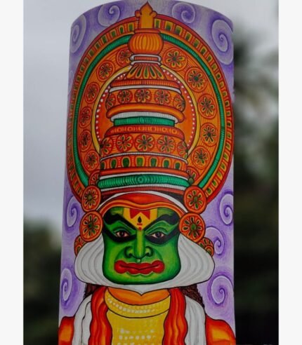 Hand-painted terracotta vase titled Kathakali Reverie by Akshaya Sivadas featuring a detailed green-faced Kathakali dancer with an elaborate golden crown on a lavender background.