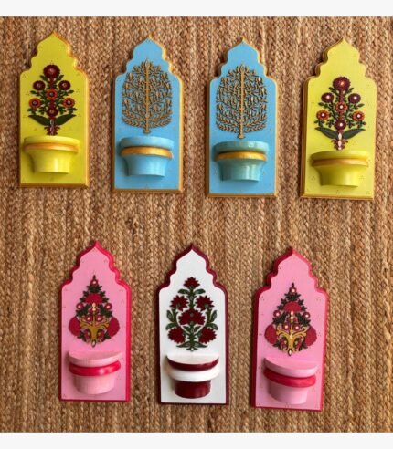 Handcrafted wooden royal jharokha wall brackets with floral motifs in pastel yellow, sky blue, pink, and white painted by artist Rucha Desai.