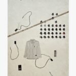 A vertical surrealist mixed media painting featuring a finely detailed pinstripe collared shirt surrounded by floating charcoal thread coils, a diagonal vintage measuring tape, and an organized grid of black garment size tags ranging from XS to XL on an off-white paper background, by Hardev Chauhan.