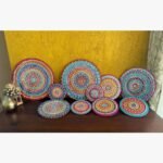 Handcrafted multi-colored Lippan art wall plates set with detailed mandala patterns and mirror work by artist Rucha Desai.