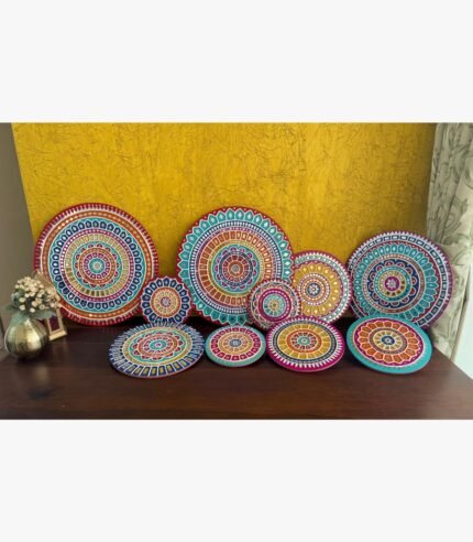 Handcrafted multi-colored Lippan art wall plates set with detailed mandala patterns and mirror work by artist Rucha Desai.