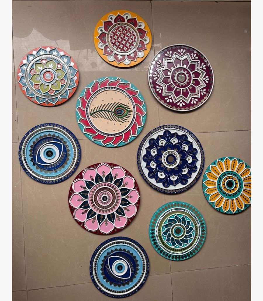 7 Handcrafted Lippan art wall plate set featuring evil eye motifs, peacock feather designs, and lotus mandalas with mirror work by artist Rucha Desai.