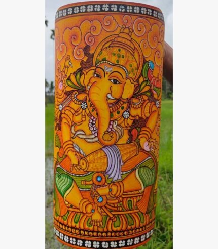 Hand-painted terracotta vase titled Mridangam Ganesha by Akshaya Sivadas featuring a detailed yellow Lord Ganesha playing a traditional drum on a golden ochre background.